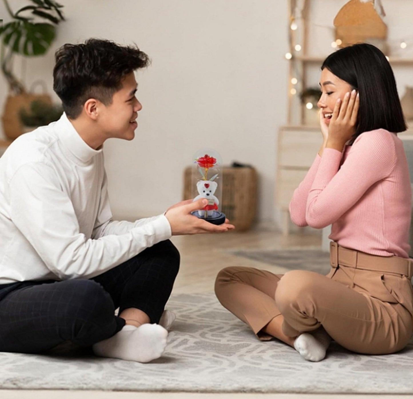 Romantični poklon za Dan zaljubljenih – staklena kupola sa ružom i medvedićem na drvenoj površini.