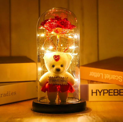 Staklena kupola sa crvenom ružom i plišanim medvedićem u crvenoj suknjici sa natpisom "I LOVE YOU".